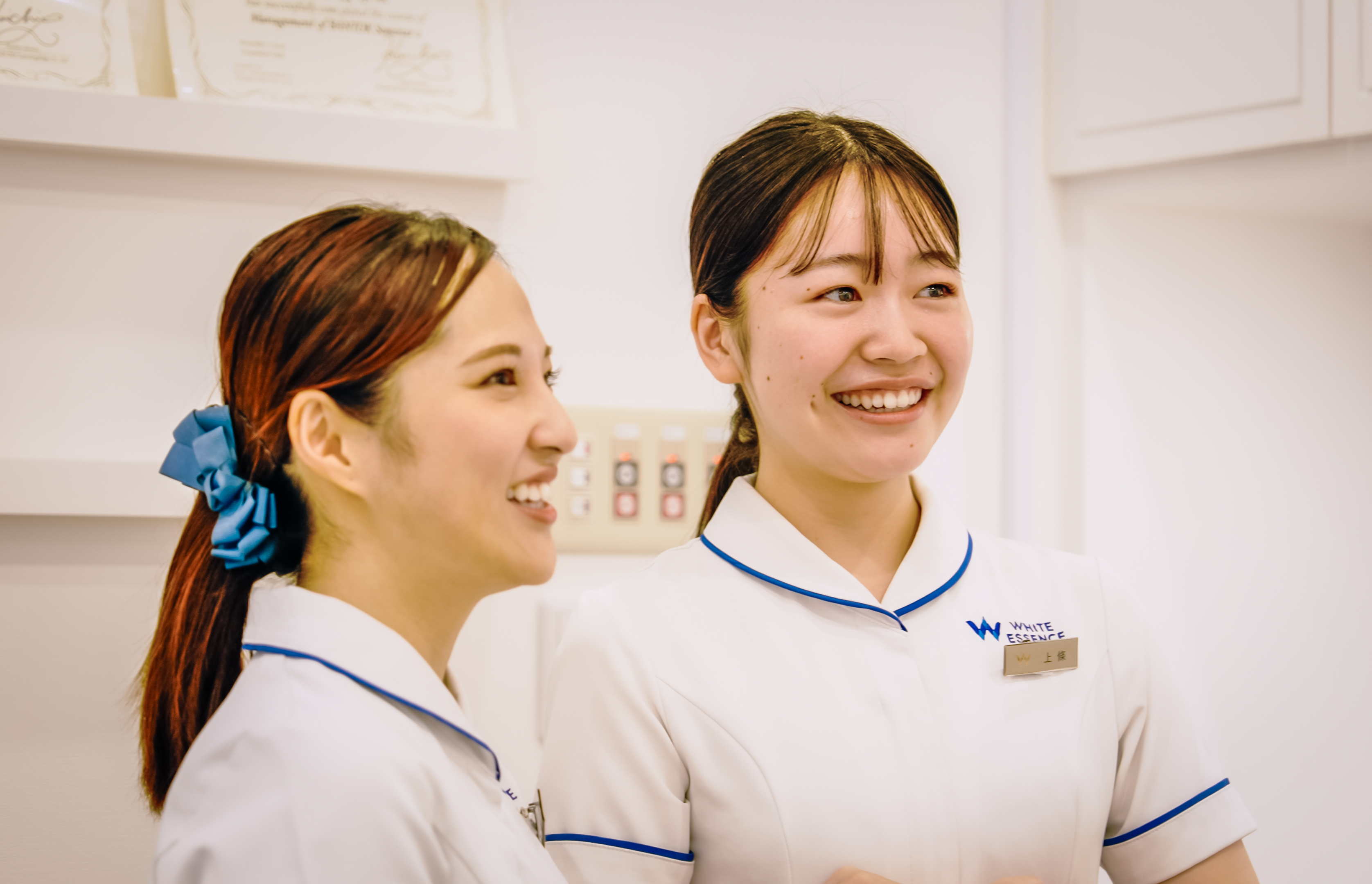 Two staff members smiling in clinic room